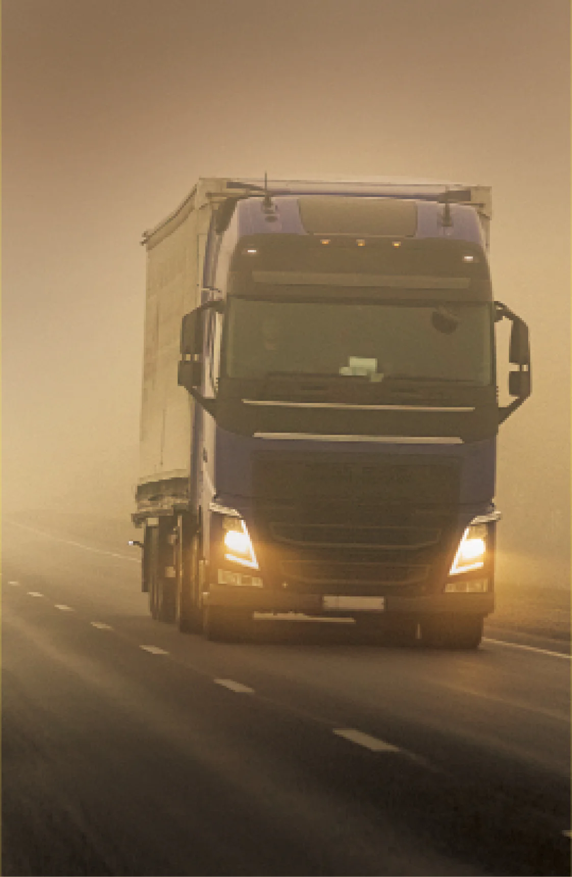 Caminhão semi-reboque em movimento em uma estrada nebulosa, simbolizando a travessia em condições de baixa visibilidade.